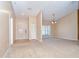 Open living room features neutral paint, carpeted floors, and natural light from a large window at 12846 Tallowood Dr, Riverview, FL 33569