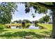 Scenic view of a tranquil pond surrounded by lush greenery, trees and well-manicured lawns at 12846 Tallowood Dr, Riverview, FL 33569