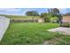 Spacious backyard featuring a lush lawn, shed, white fence and patio area, perfect for outdoor activities and relaxation at 13246 Kent Bradley St, Dade City, FL 33525
