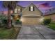 Charming two-story home with a well-manicured lawn and a two-car garage, showcasing its inviting curb appeal at 13246 Kent Bradley St, Dade City, FL 33525