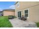 Concrete patio with outdoor seating and view of the grassy backyard at 13246 Kent Bradley St, Dade City, FL 33525