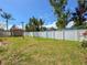 Spacious backyard with a well-maintained lawn, a wooden shed, and a sturdy white fence for privacy and security at 13263 86Th Ave, Seminole, FL 33776