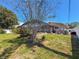 Backyard view of a house with screen enclosure, lush green lawn, and landscape with flowering bushes at 13263 86Th Ave, Seminole, FL 33776