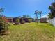 Expansive backyard with a screened-in patio, a shed, palm trees, and colorful flowers, offering a tranquil retreat at 13263 86Th Ave, Seminole, FL 33776