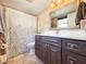 The bathroom has a vanity with a white countertop and dark wood cabinets, along with a large mirror at 13263 86Th Ave, Seminole, FL 33776