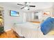 This bright bedroom features gray walls, a ceiling fan, and a modern mounted television, and stylish decor at 13263 86Th Ave, Seminole, FL 33776