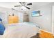 This well-lit bedroom has light gray walls and white trim with wood floors, ceiling fan, and a mounted television at 13263 86Th Ave, Seminole, FL 33776