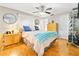 This cozy bedroom has bright wood floors, ceiling fan, dresser, and a door leading to the rest of the house at 13263 86Th Ave, Seminole, FL 33776