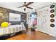 Bedroom featuring hardwood floors, ceiling fan, and chalkboard paint wall and shelving at 13263 86Th Ave, Seminole, FL 33776