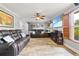 Spacious living room with plush leather sofas, tile flooring, and a ceiling fan at 13263 86Th Ave, Seminole, FL 33776