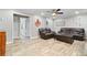 Cozy living room features wood-look tile flooring, ceiling fan, and comfortable seating with easy access to other rooms at 13263 86Th Ave, Seminole, FL 33776