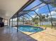 The screened-in pool has a geometric shape and is surrounded by a paver patio and lush landscaping at 13263 86Th Ave, Seminole, FL 33776