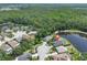 Aerial view of a house and pond with lush trees and neighborhood surrounding the property at 14502 Pond Cypress Way, Tampa, FL 33626