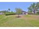 View of the backyard showcasing a screened pool and green grass under a blue sky at 14502 Pond Cypress Way, Tampa, FL 33626