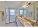 Modern bathroom with double sinks, a large mirror, and a glass-enclosed shower at 14502 Pond Cypress Way, Tampa, FL 33626