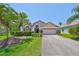 Charming single-story home featuring a well-manicured lawn and tropical palm trees at 14502 Pond Cypress Way, Tampa, FL 33626