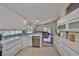 Well-lit kitchen with white cabinets, stainless appliances, and a view into the spacious living area at 14502 Pond Cypress Way, Tampa, FL 33626