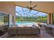 The screened-in pool offers comfortable seating, a fan, and views of a lush landscape at 14502 Pond Cypress Way, Tampa, FL 33626