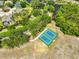 Aerial view of well-maintained community tennis courts amidst lush greenery and surrounding neighborhood at 14502 Pond Cypress Way, Tampa, FL 33626