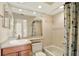 Bathroom features a tub, shower, granite countertops, tile walls and a decorative shower curtain at 14561 El Paseo Dr, Seminole, FL 33776