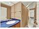 Compact bathroom with blue countertop, modern toilet, and a large mirror at 14561 El Paseo Dr, Seminole, FL 33776