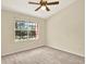 Neutral bedroom with a ceiling fan and a large window providing natural light at 14561 El Paseo Dr, Seminole, FL 33776