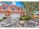 Charming pink townhouse featuring a two-car garage and lush landscaping at 14561 El Paseo Dr, Seminole, FL 33776