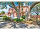 Charming two-story pink home with mature trees shading the property at 14561 El Paseo Dr, Seminole, FL 33776