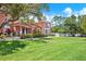 Community clubhouse building on a grassy lawn with palm trees and blue skies at 14561 El Paseo Dr, Seminole, FL 33776