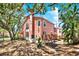 Rear exterior view of a pink two-story home with a wooden deck at 14561 El Paseo Dr, Seminole, FL 33776