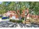 Beautiful pink townhome with mature trees, offering shade and curb appeal at 14561 El Paseo Dr, Seminole, FL 33776