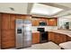 Bright kitchen with wood cabinets, stainless steel refrigerator and skylight at 14561 El Paseo Dr, Seminole, FL 33776