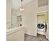 Open landing area with stacked laundry and an adjacent bathroom at 14561 El Paseo Dr, Seminole, FL 33776