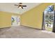Spacious living room with neutral carpet, large windows, and a ceiling fan at 14561 El Paseo Dr, Seminole, FL 33776