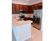 Well-lit kitchen featuring stainless steel appliances, wood cabinets, and stone countertops at 1508 Talisker Dr, Clearwater, FL 33755