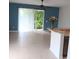 Bright living area features blue accent wall, tile floors, a ceiling fan, and sliding glass doors to outside at 1508 Talisker Dr, Clearwater, FL 33755