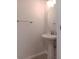 Powder room featuring a pedestal sink, round mirror, and neutral walls at 1508 Talisker Dr, Clearwater, FL 33755