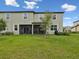 Backyard featuring a lush green lawn, screened-in patio, and mature trees at 17729 Nectar Flume Dr, Land O Lakes, FL 34638