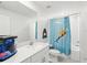 Bright bathroom featuring a shower with a cute animal-themed curtain and white tiling at 17729 Nectar Flume Dr, Land O Lakes, FL 34638