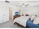 Well-lit bedroom featuring carpet, a ceiling fan, tv, and a door to a bathroom at 17729 Nectar Flume Dr, Land O Lakes, FL 34638