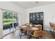 Cozy dining room with round wooden table, leather chairs, and sliding glass doors to the backyard at 17729 Nectar Flume Dr, Land O Lakes, FL 34638