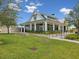 Stunning exterior view of a modern farmhouse-style building with a well-manicured lawn at 17729 Nectar Flume Dr, Land O Lakes, FL 34638