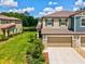 Two-story home with a well-manicured lawn, a two-car garage, and a water view at 17729 Nectar Flume Dr, Land O Lakes, FL 34638