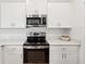 Close-up of modern kitchen featuring stainless steel appliances and white cabinets at 17729 Nectar Flume Dr, Land O Lakes, FL 34638