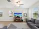 Bright living room featuring neutral walls, wood floors, ceiling fan, and plenty of natural light at 17729 Nectar Flume Dr, Land O Lakes, FL 34638