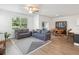 Bright living room and dining space with gray sofas, modern rug, and plenty of natural light at 17729 Nectar Flume Dr, Land O Lakes, FL 34638