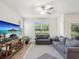 Bright living room featuring wood floors, gray sofas, ceiling fan, and views of the lake at 17729 Nectar Flume Dr, Land O Lakes, FL 34638