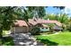 Charming home exterior with a well-manicured front yard, lush landscaping, and a brick driveway at 1903 Curry Rd, Lutz, FL 33549