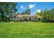 Stunning single story home with a lush green lawn, mature trees, and beautiful landscaping at 1903 Curry Rd, Lutz, FL 33549