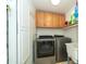 Functional laundry room with stainless steel washer, dryer, and plenty of cabinet storage space at 1903 Curry Rd, Lutz, FL 33549
